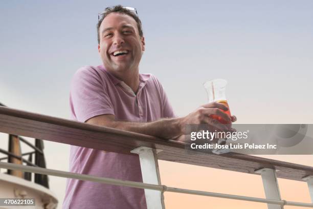 caucasian man smiling on cruise ship deck - railings ストックフォトと画像