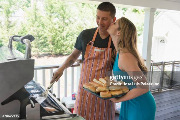 caucasian couple barbecuing on porch - panecillo de perrito caliente fotografías e imágenes de stock