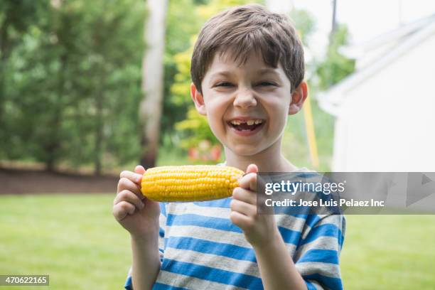 caucasian boy eating corn on the cob - corn cob photos et images de collection