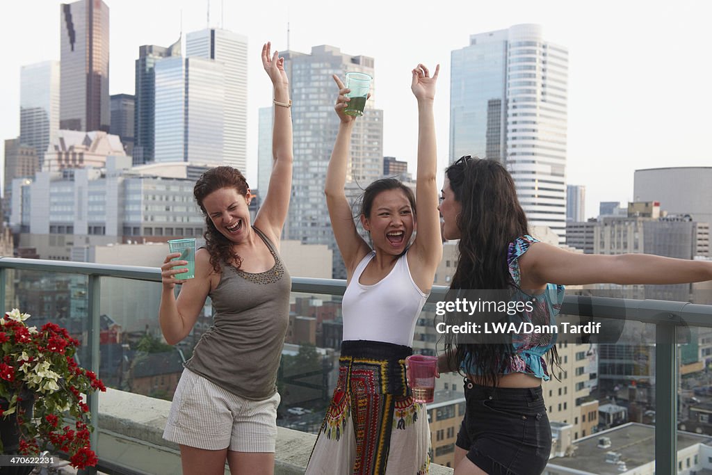 Women enjoying cocktails on urban rooftop