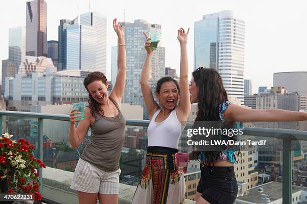 women enjoying cocktails on urban rooftop - day toronto stockfoto's en -beelden