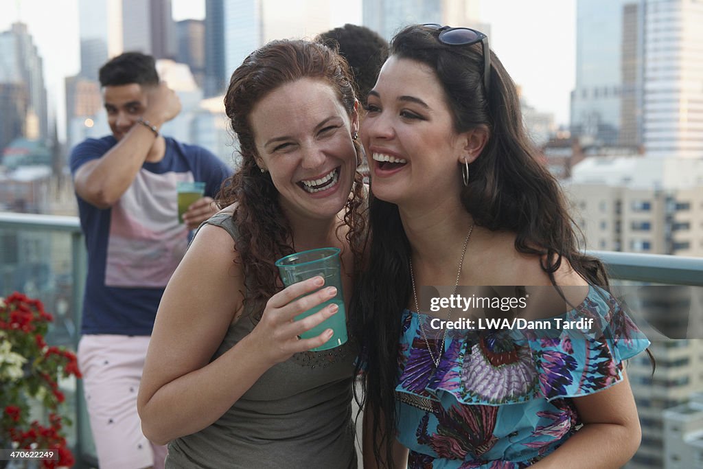 Friends enjoying cocktails on urban rooftop