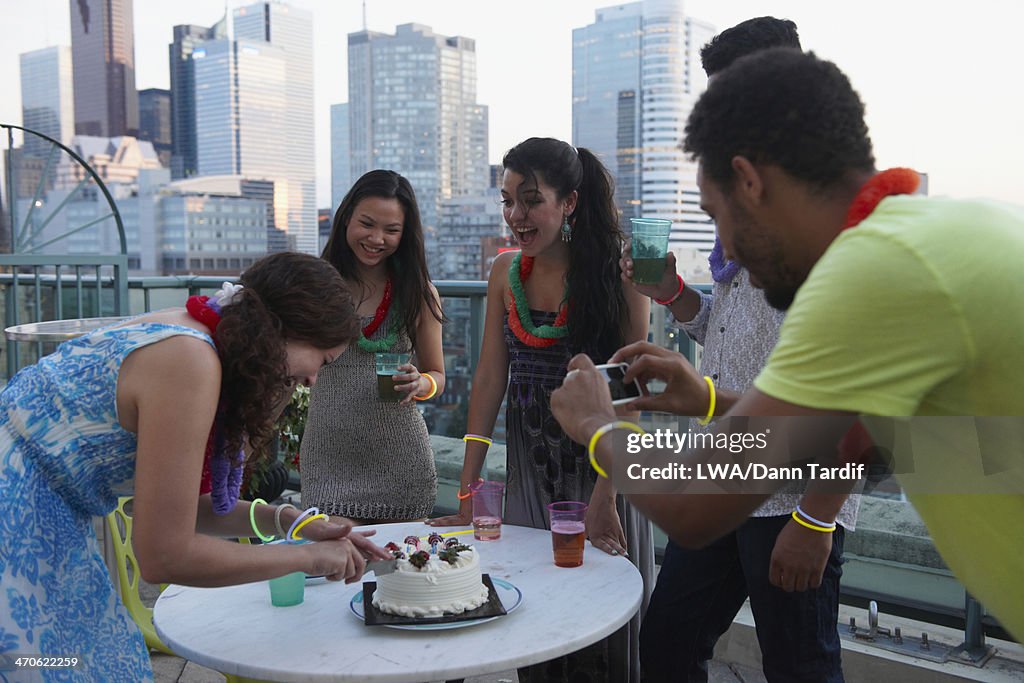 Friends celebrating birthday on urban rooftop