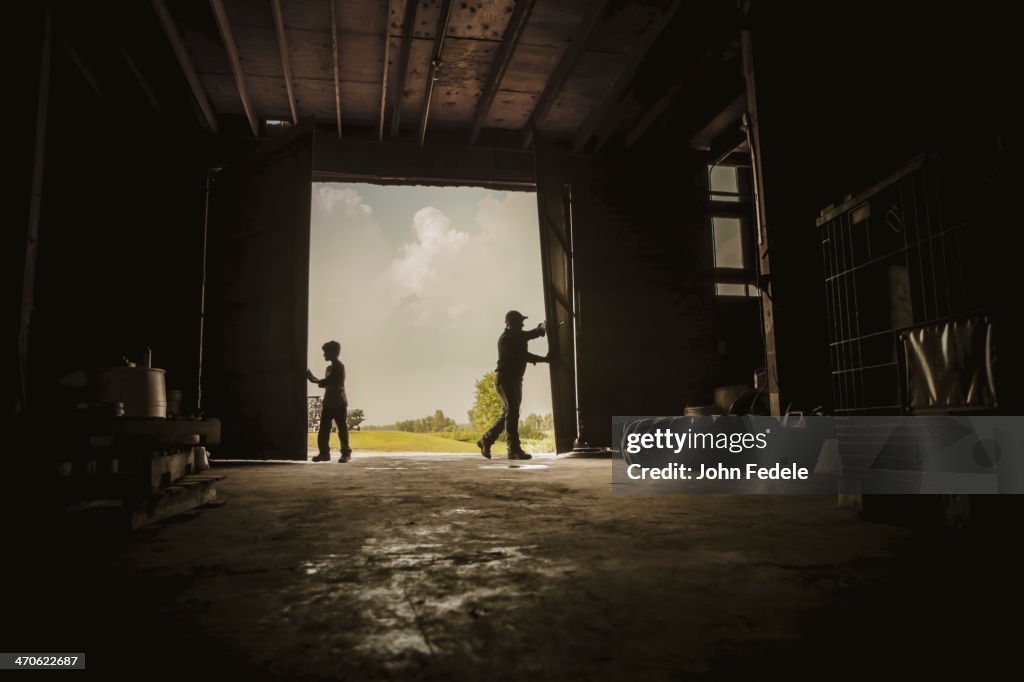 Caucasian farmer and son working in barn