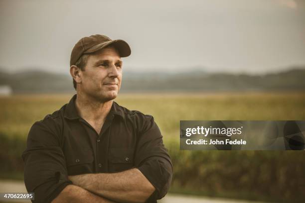 caucasian farmer overlooking crop fields - place stock-fotos und bilder