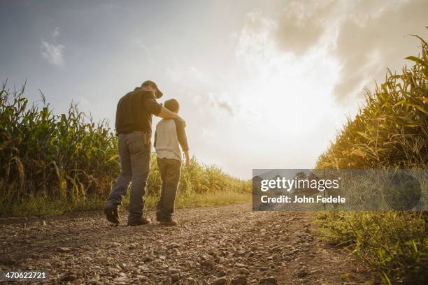 caucasian father and son walking on dirt road through farm - missouri farm stock pictures, royalty-free photos & images