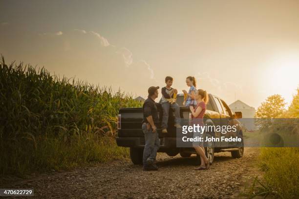 caucasian family on truck on dirt road - couple farm photos et images de collection
