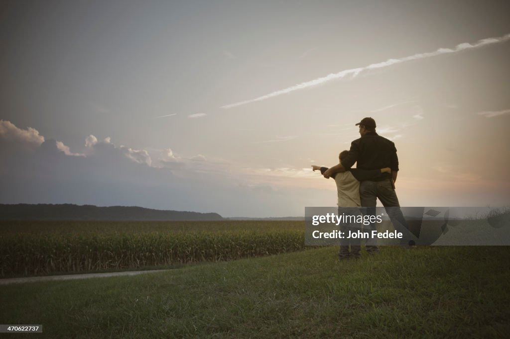 Caucasian father and son overlooking crop fields
