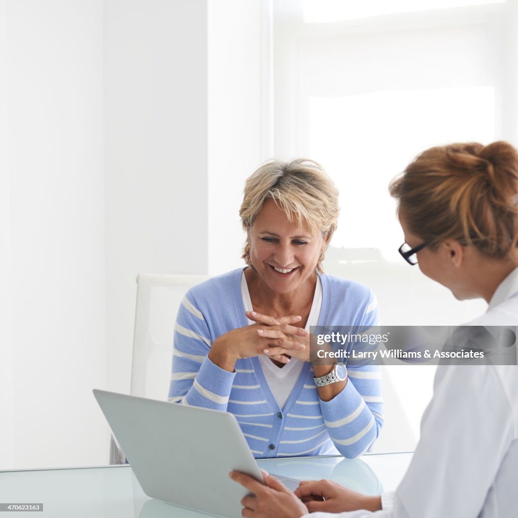 Caucasian doctor and patient talking in office