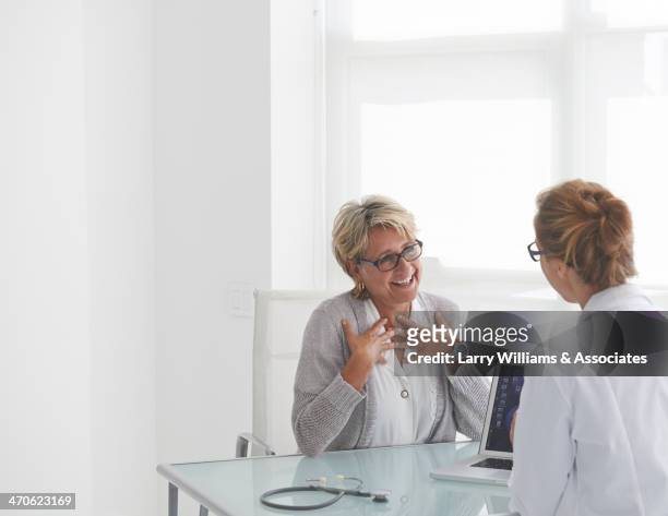 caucasian doctor and patient talking in office - heilbehandlung stock-fotos und bilder