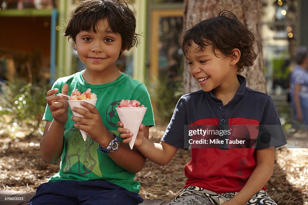 Mixed race boys eating ice cream outdoors