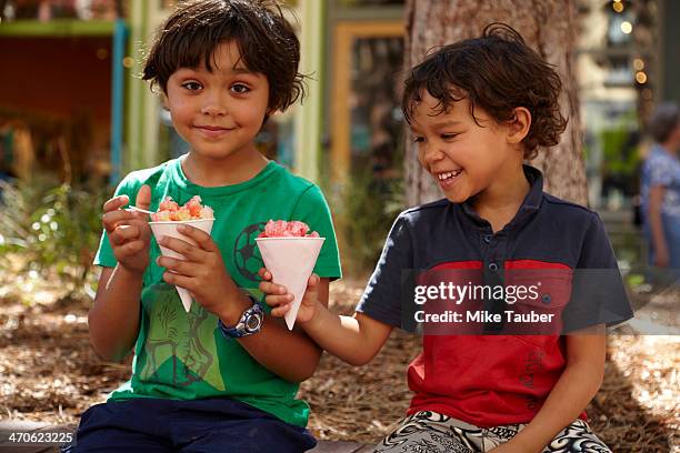 mixed race boys eating ice cream outdoors - snow cones shaved ice stock pictures, royalty-free photos & images