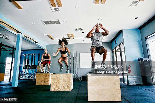 people working out in gym - entrenamiento combinado fotografías e imágenes de stock