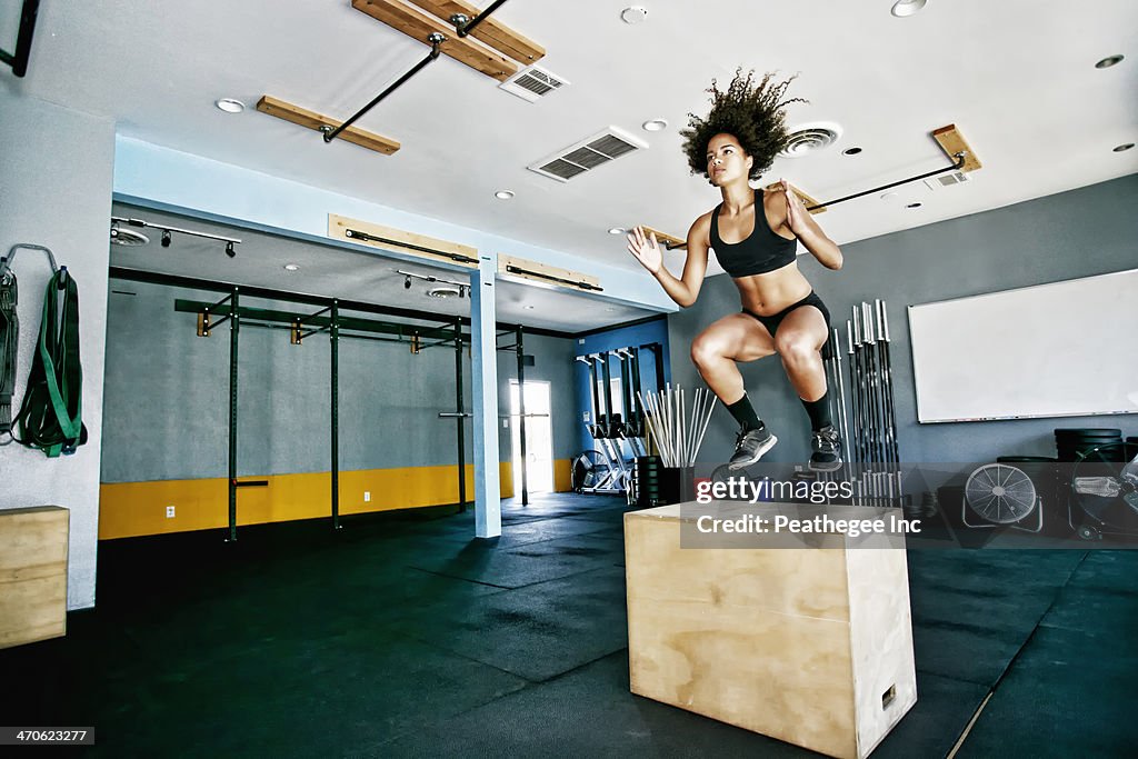 Mixed race woman working out in gym