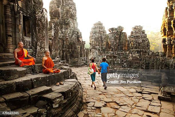couple visiting buddhist temple, angkor, siem reap, cambodia - cambodia stockfoto's en -beelden