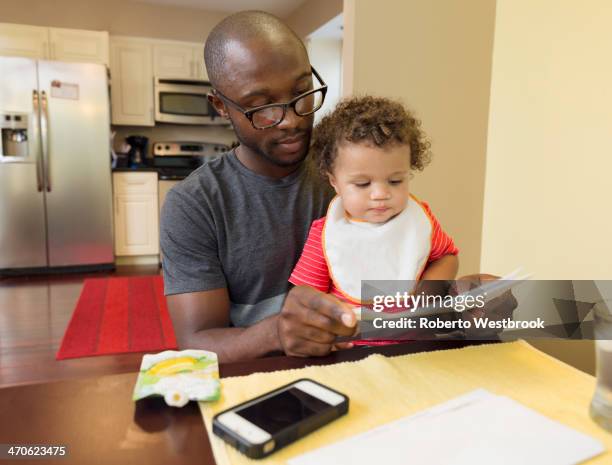 father and toddler son sitting at table - baby bib stock pictures, royalty-free photos & images