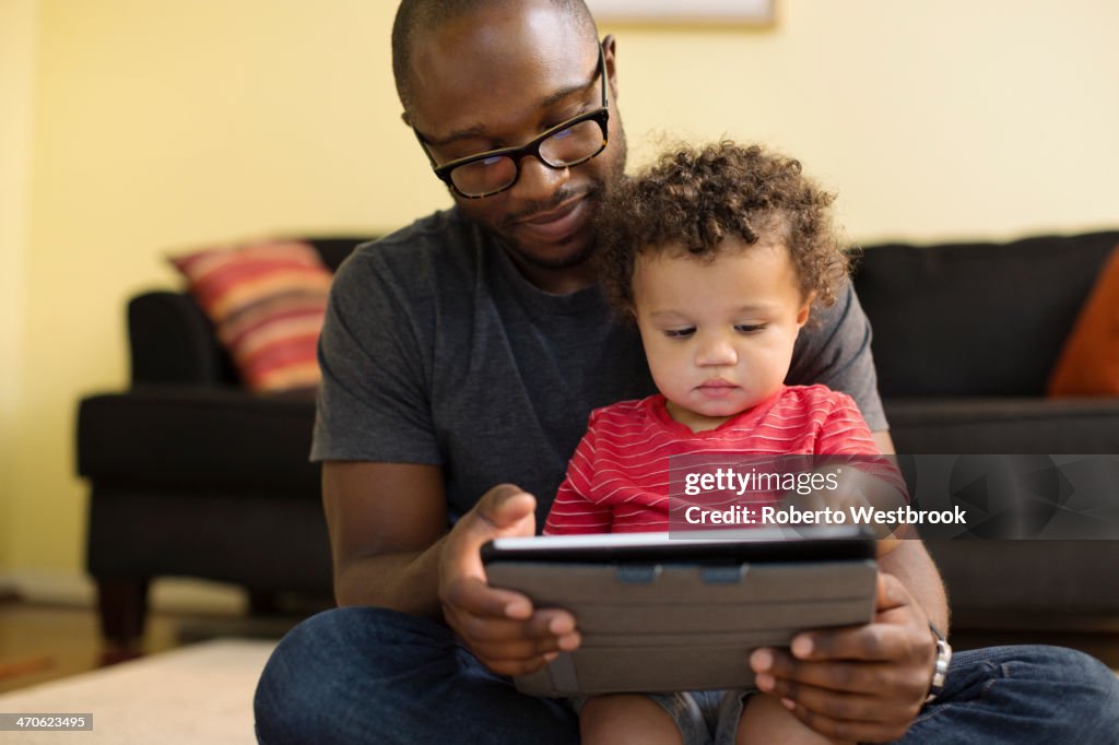 Father and toddler using digital tablet