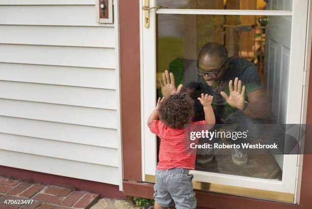 father and toddler son playing at screen door - porta de tela imagens e fotografias de stock