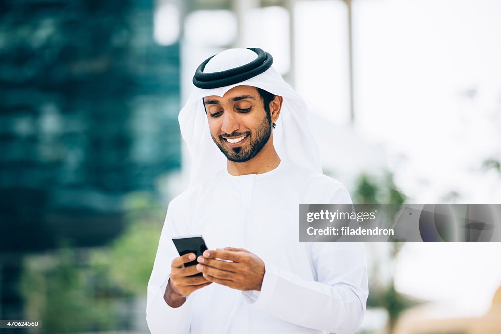 Emirati usando un teléfono inteligente