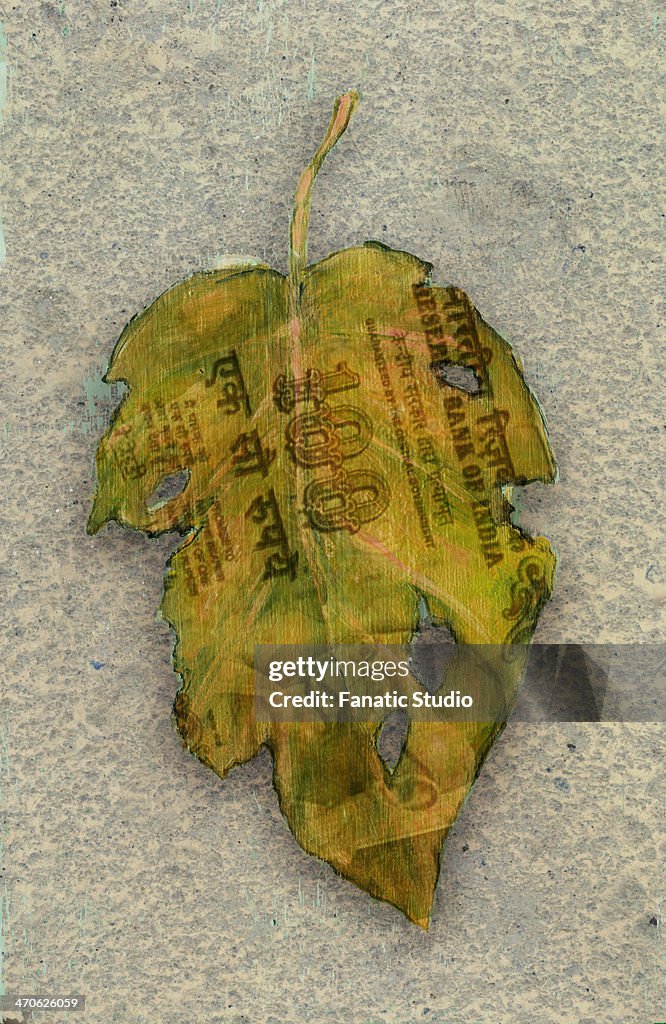 Illustrative image of Indian rupee note printed on maple leaf representing recession