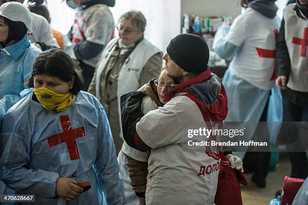 Medics embrace in the lobby of the Hotel Ukraine, which has been converted to a medical clinic and makeshift morgue, on February 20, 2014 in Kiev,...