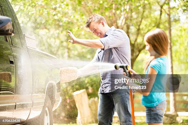 father and daughter wash the family vehicle together outdoors. - family cleaning stock pictures, royalty-free photos & images