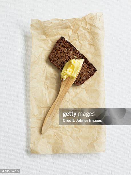 rye bread and butter knife with butter on paper, studio shot - dark bread stock pictures, royalty-free photos & images
