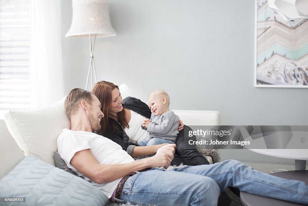 Happy parents with son on sofa