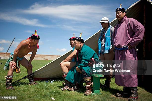 Mongolian wrestlers prepare for matches during a Naadam festival. Mongolian pastoral herders make up one of the world's largest remaining nomadic...