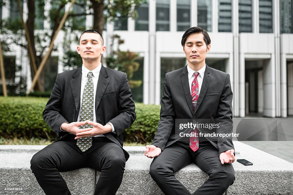 Japanische Business Mann tun yoga zusammen auf die Innenstadt
