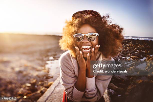 fun-loving african american teenage hipster at the beach laughing - funny black girl stock pictures, royalty-free photos & images