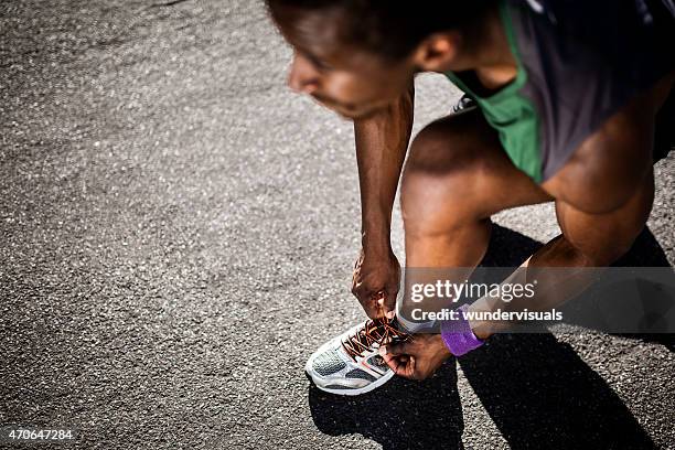 african american runner tying his laces and looking ahead - guy tied up stock pictures, royalty-free photos & images