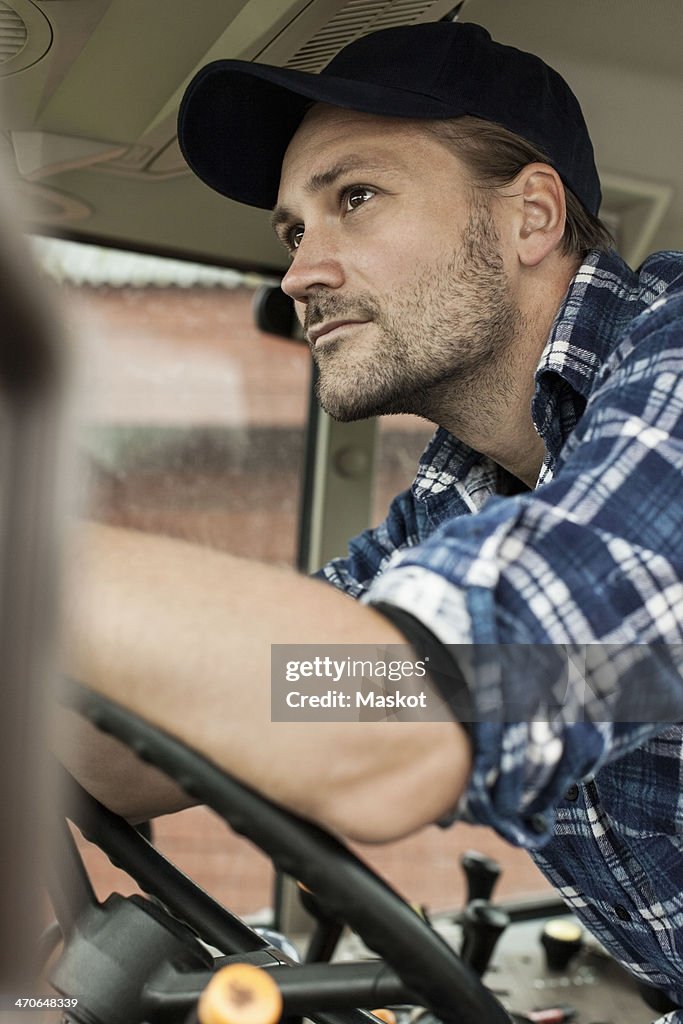 Thoughtful farmer driving tractor
