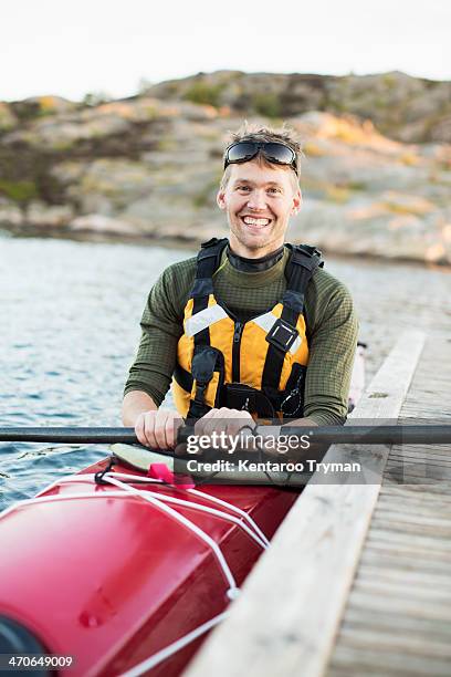 portrait of happy man kayaking in river - schwimmweste stock-fotos und bilder