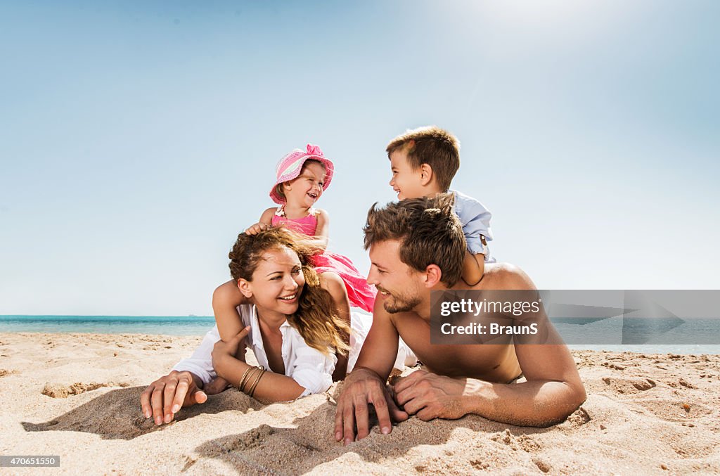 Young happy family relaxing at the beach and talking.