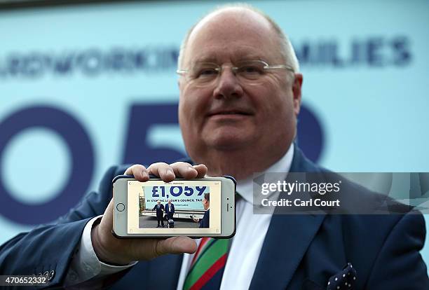 Secretary of State for Communities and Local Government, Eric Pickles, holds up his phone showing a photograph taken of himself and London Mayor and...