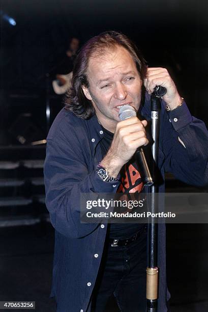 "The Italian rock singer Vasco Rossi, leaning on the microphone holder, is singing during one of the concerts of his tour Nessun pericolo... Per te....