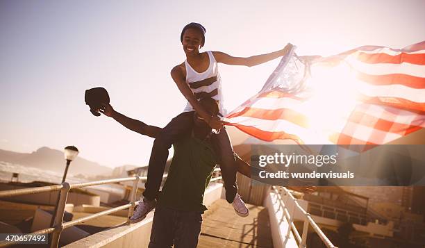 happy teenagers proudly displaying an american flag - curly waves stock pictures, royalty-free photos & images