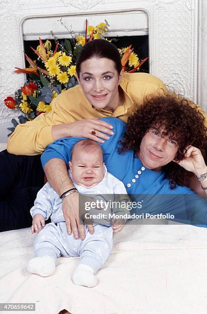 "Portrait of the Cocciante family, with the songwriter Riccardo, recently winner of Sanremo Music Festival, laying on the bed, posing with his wife...