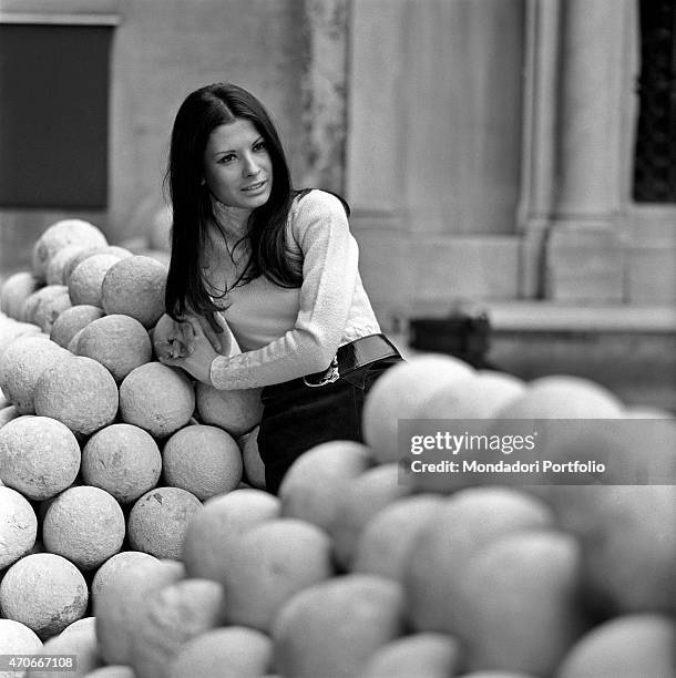 "Italian singer Rosanna Fratello poses leaning herself against a pile of cannonballs; she started her career at a tender age, then became famous...