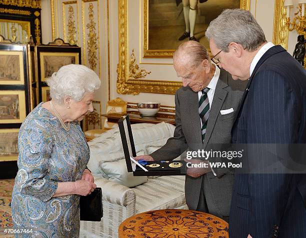 Queen Elizabeth II with the Australian High Commissioner Alexander Downer as she presents the Prince Philip, Duke of Edinburgh with the Insignia of a...