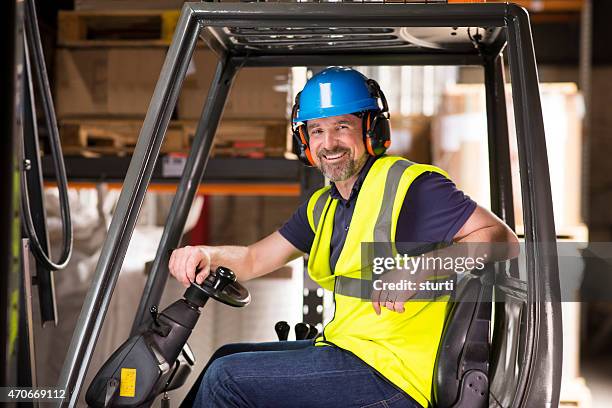 happy mature forklift truck driver smiling to camera - ear defenders stock pictures, royalty-free photos & images