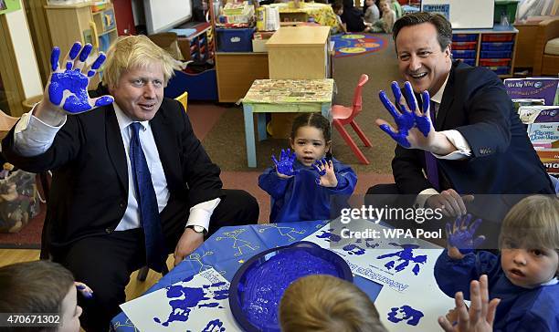 London Mayor Boris Johnson and Prime Minister David Cameron react as they join a hand-printing session with children at the Advantage children's...