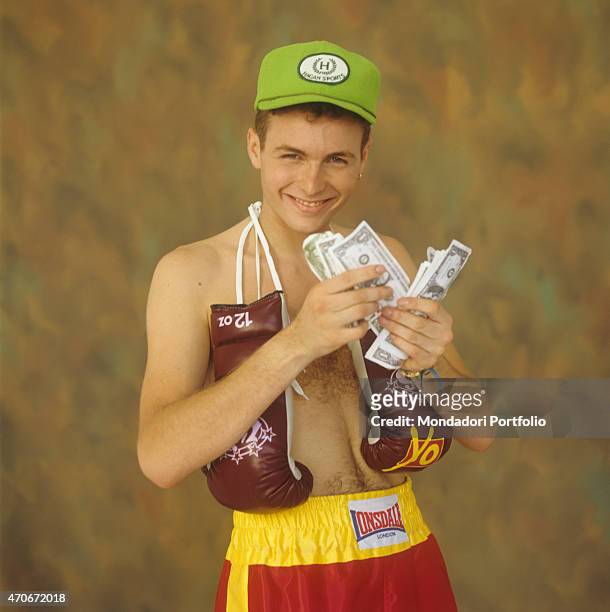Italian singer-songwriter and rapper Jovanotti counting many American notes wearing boxing gloves and Lonsdale shorts. 1988