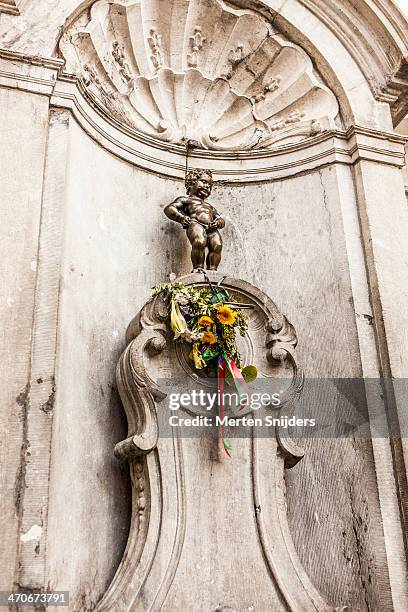 manneke pis doing what he does - manneke pis stock pictures, royalty-free photos & images