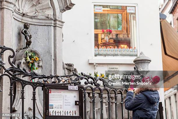 tourist photographing manneke pis - manneke pis stock pictures, royalty-free photos & images