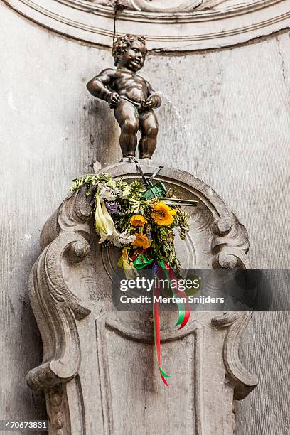 manneke pis doing what he does - manneke pis stock pictures, royalty-free photos & images