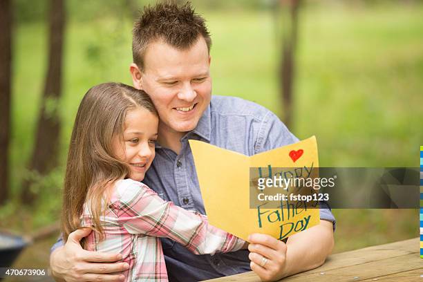daughter shows dad handmade father's day card. outdoors. child, parent. - receiving card stock pictures, royalty-free photos & images