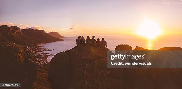 panoramic view of silhouetted hipster watching the sunset over sea - girl panoramic stock pictures, royalty-free photos & images