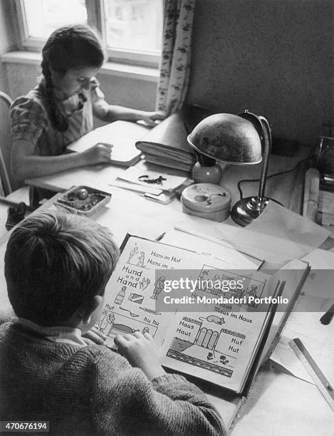 Boy learning reading and writing in German using an alphabet book. Sudtiroler Volkspartei's leaders say that the equalization of Italian and German...